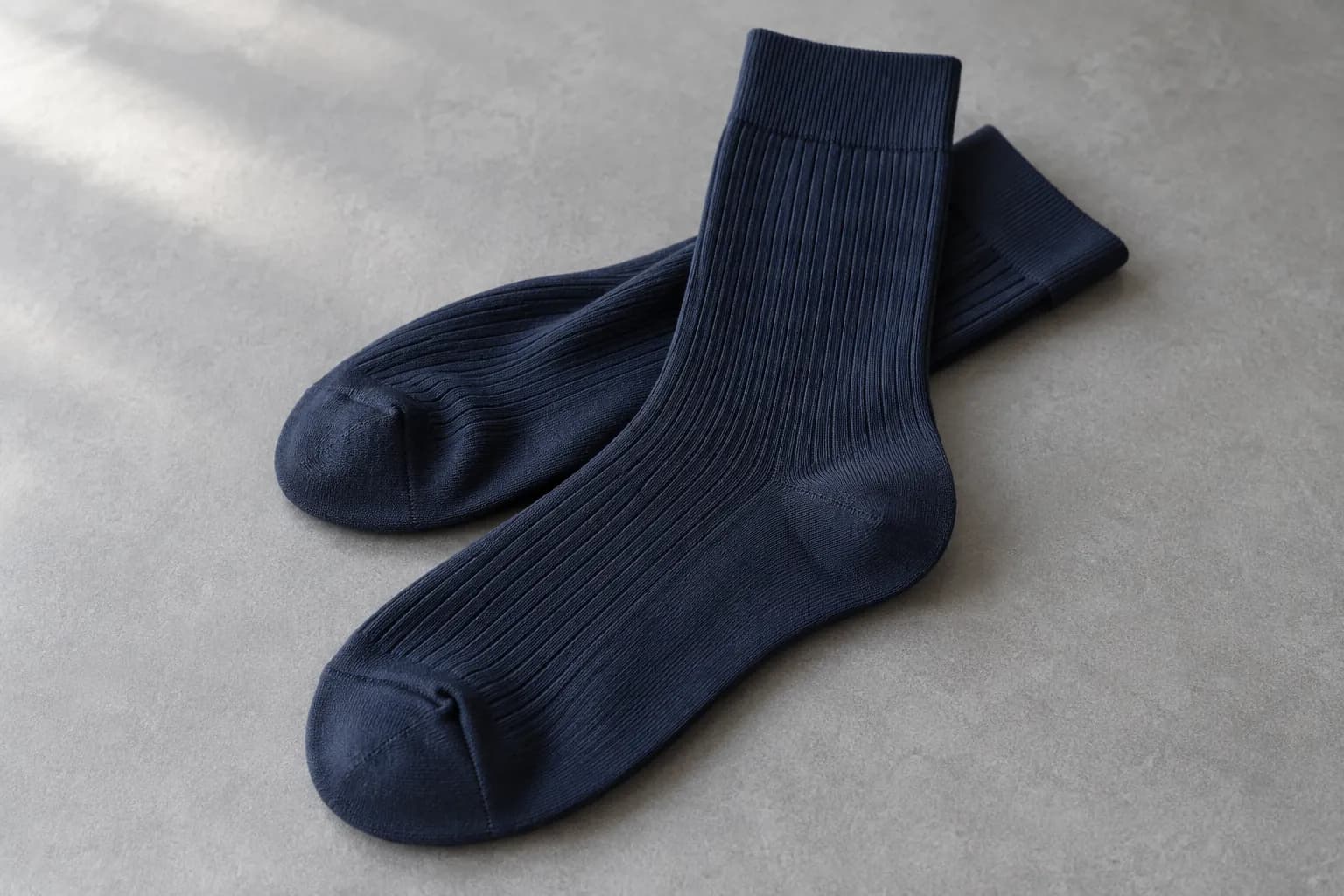 Illustrative navy fine-rib dress socks with visible heel and toe details