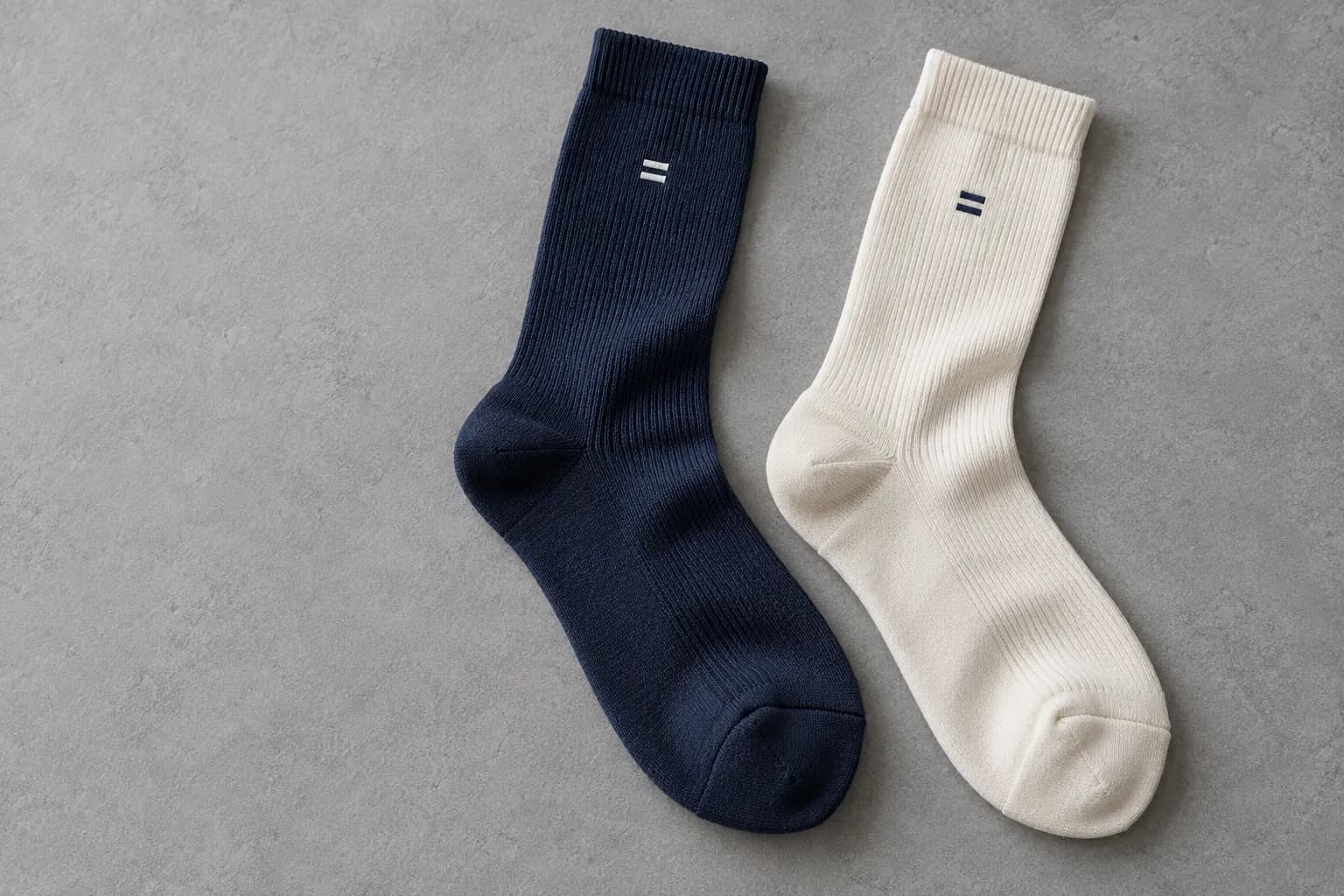 Illustrative navy and ivory crew socks with small two-bar knit motifs