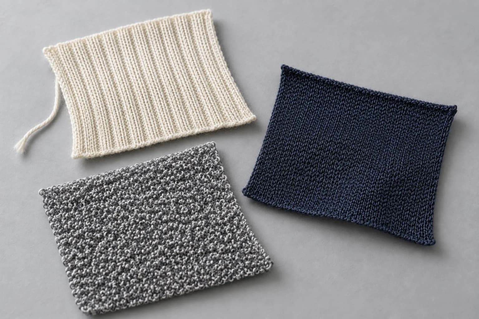Illustrative ivory rib-knit, navy smooth-knit and grey looped-texture swatches